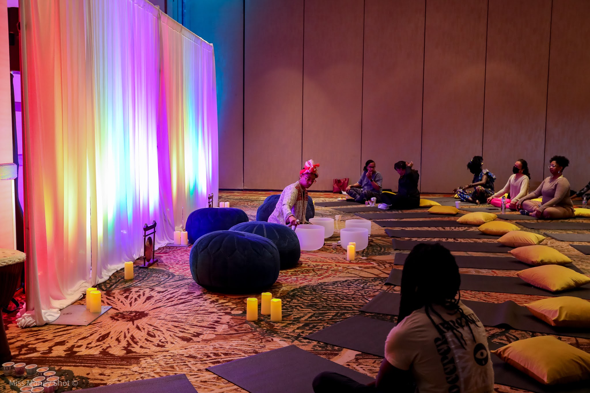 Wellness and movement session with floor pillows and colorful draping